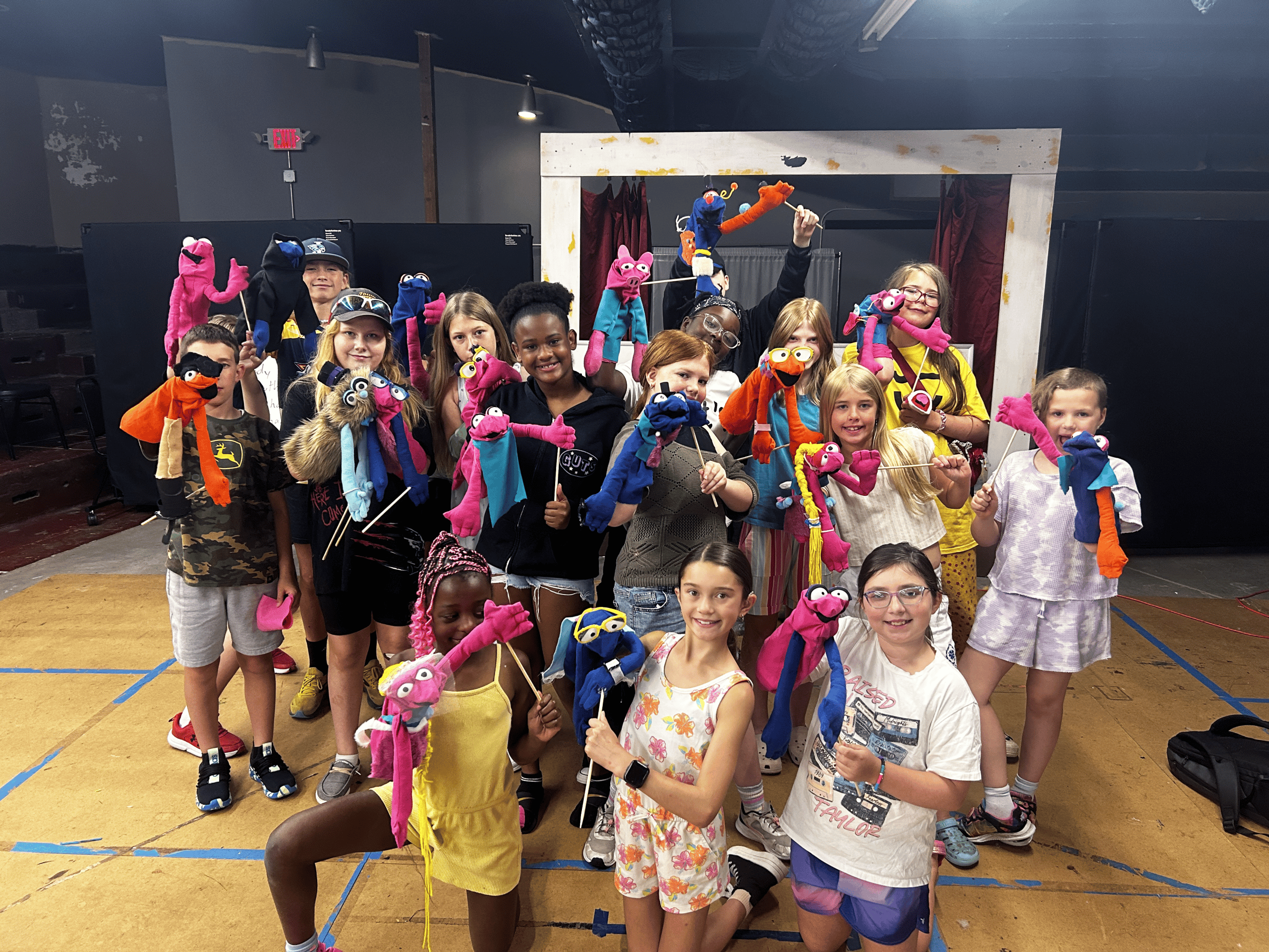A group of children show off puppets.